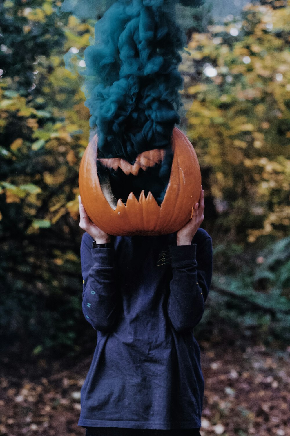 person holding Jack-O-Lantern emitting smoke