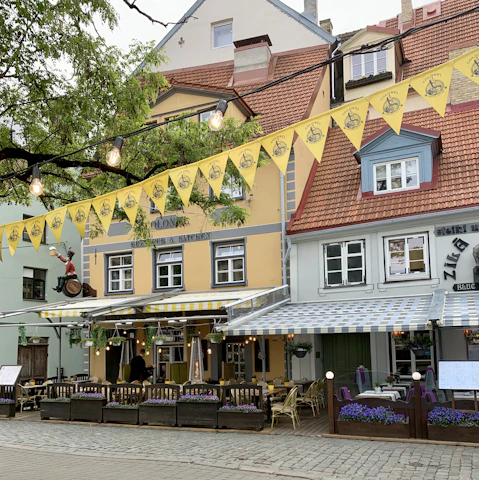 Colorful seaside guinguette with vibrant murals and open kitchen bustling with chefs.