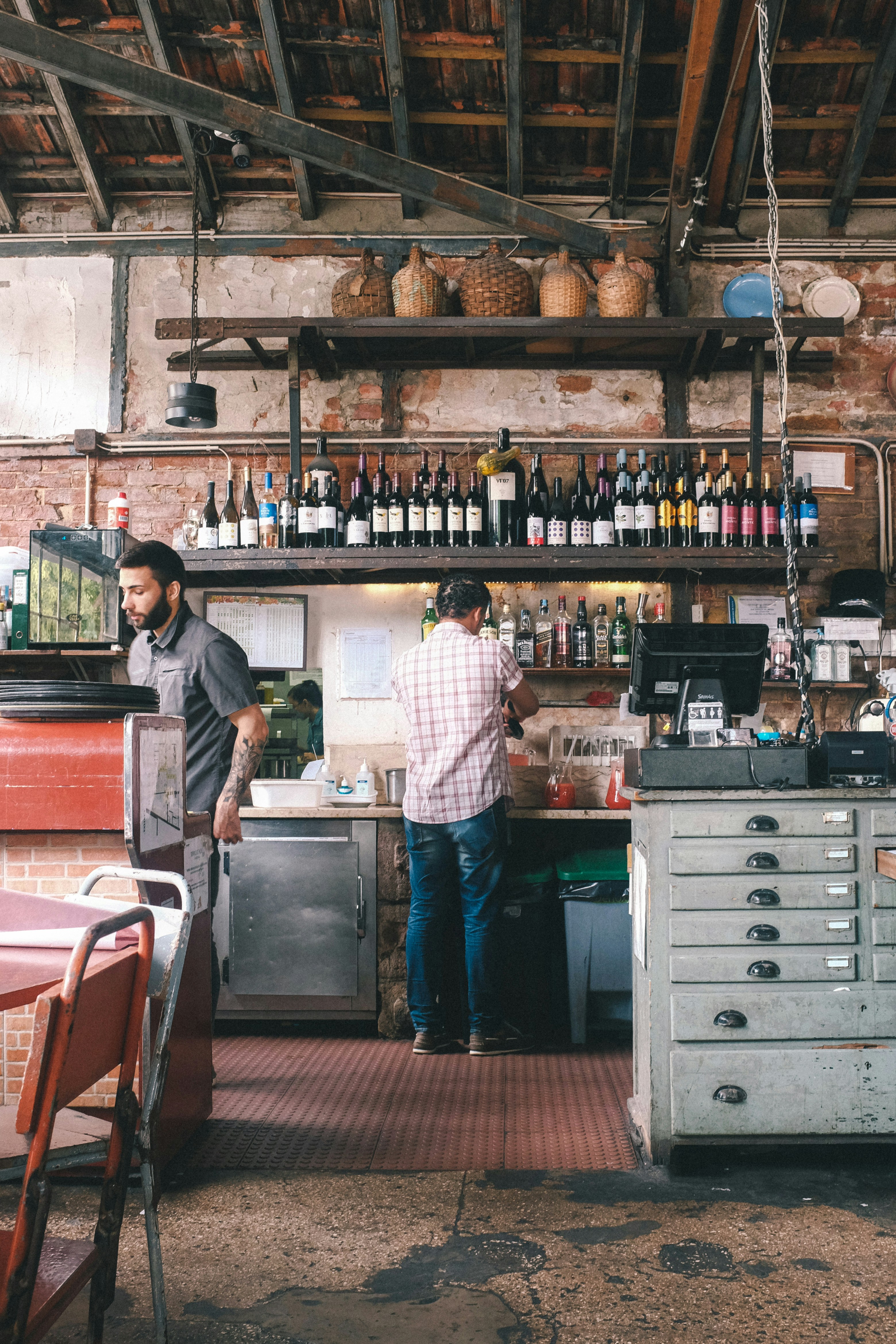 man in white and red checkered dress shirt standing in front of counter