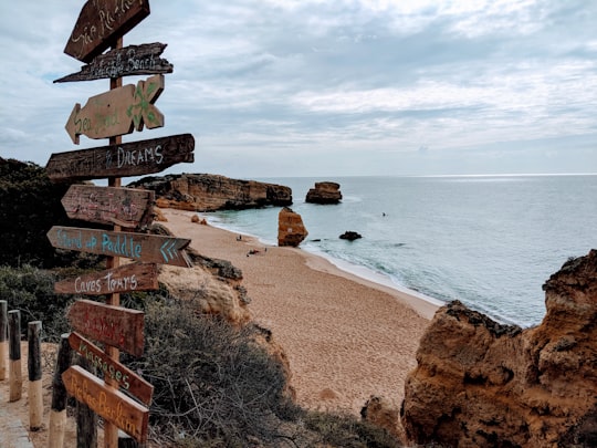 brown wooden direction sign on seashore during daytime in Albufeira Portugal