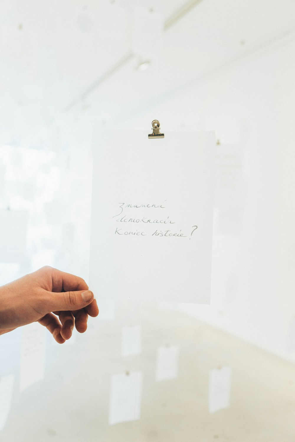 white printer paper with clip holding person's left hand