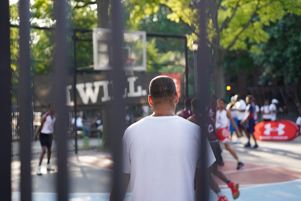 Mann sitzt auf dem Basketballplatz