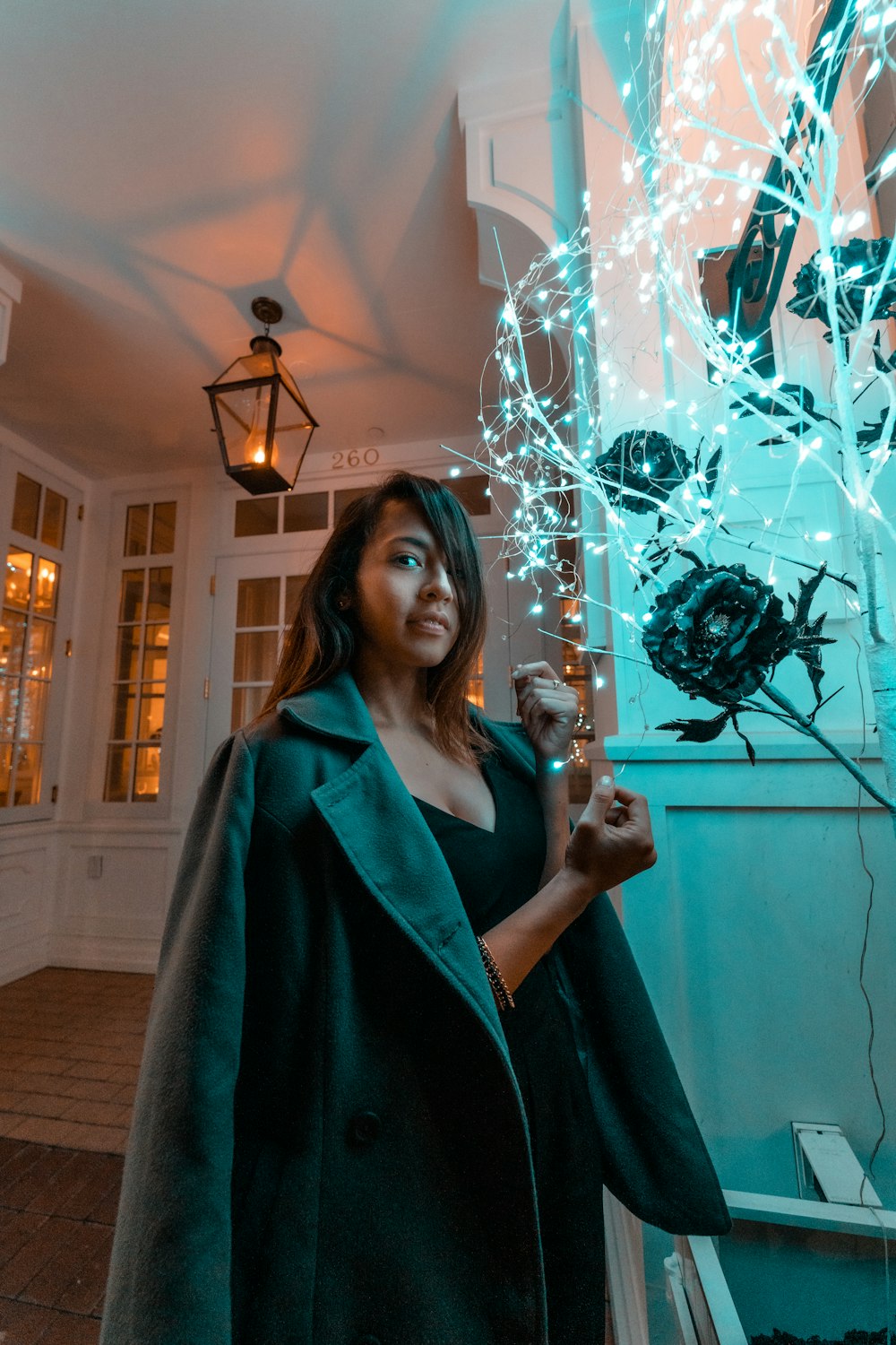 woman standing near lighted string lights