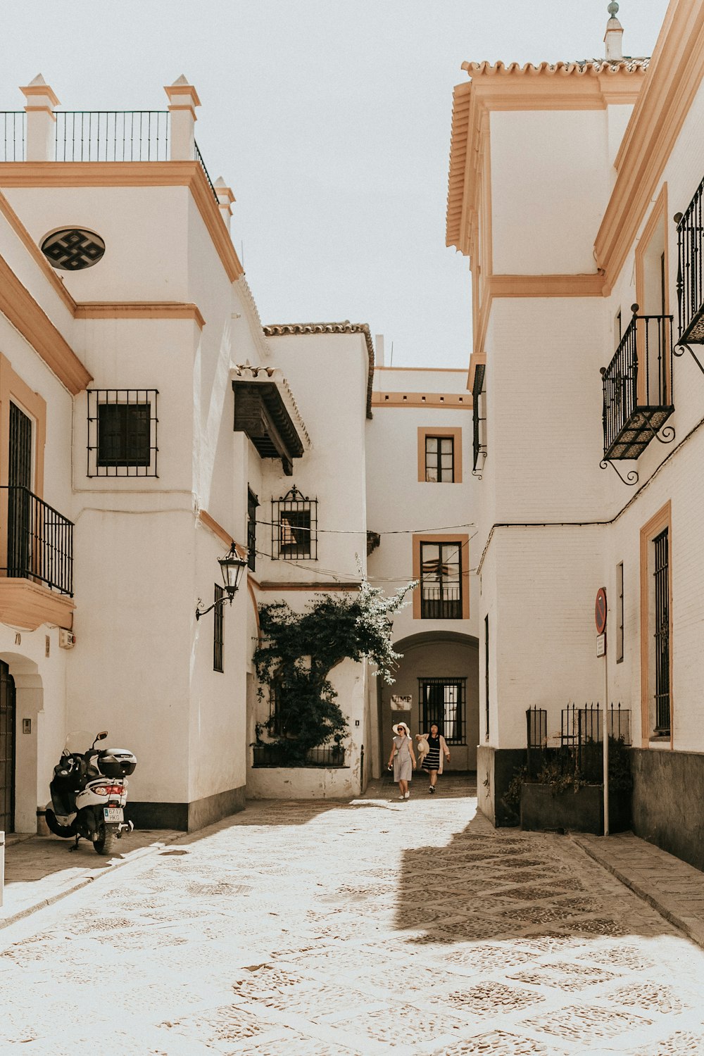 two persons walking outside white building