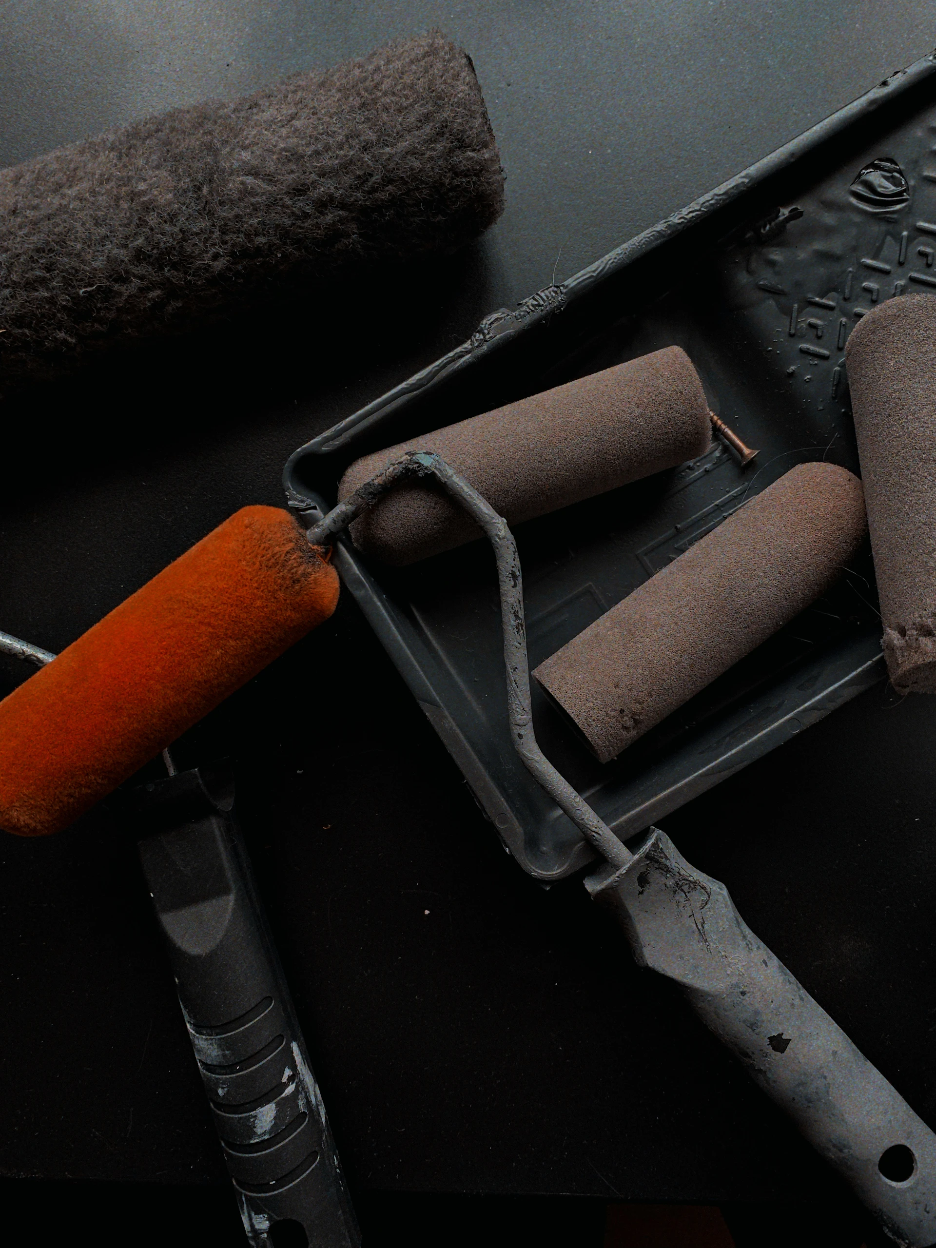 Paint rollers and tray in dramatic dark light