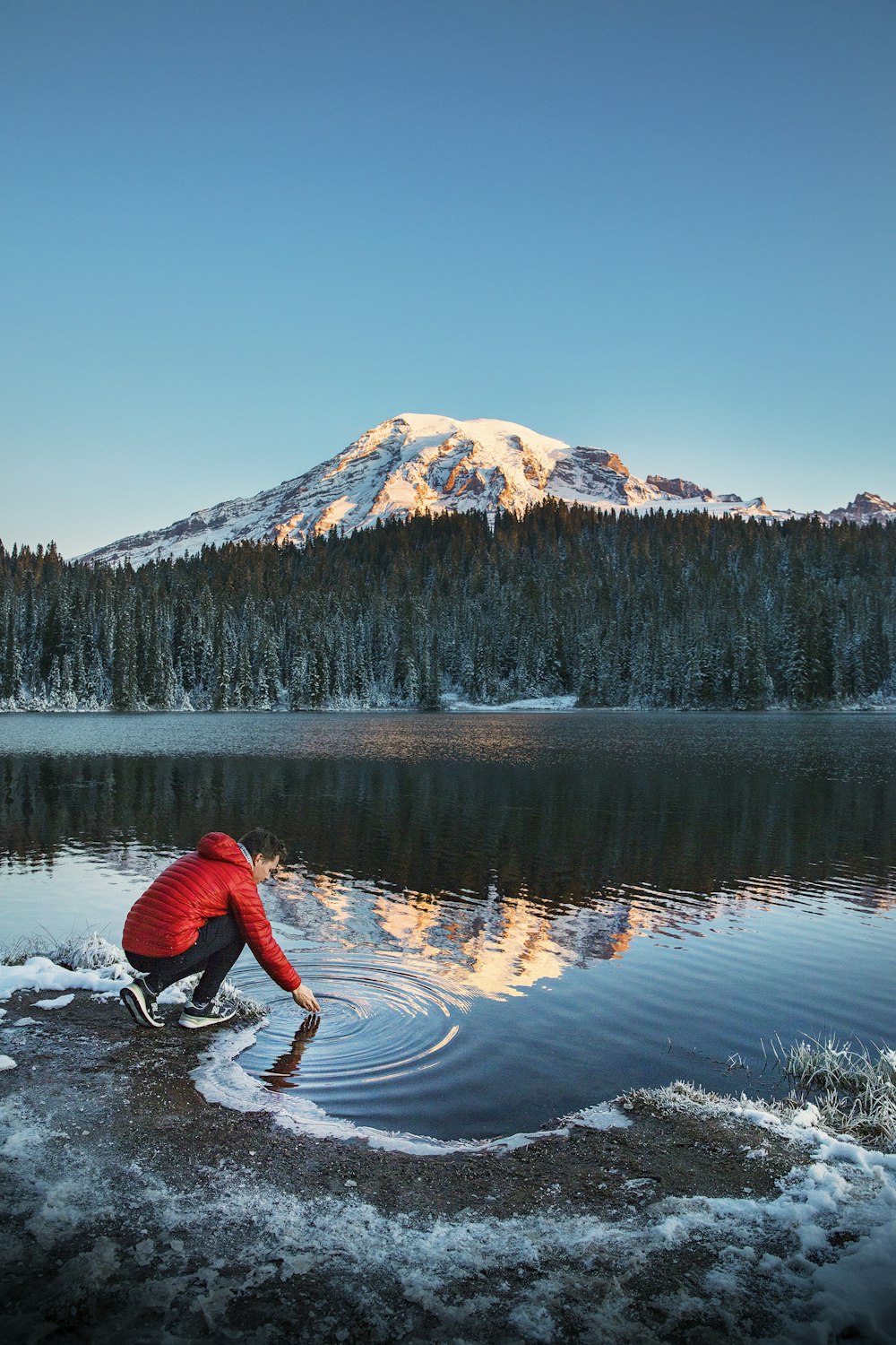 man sitting near body of water