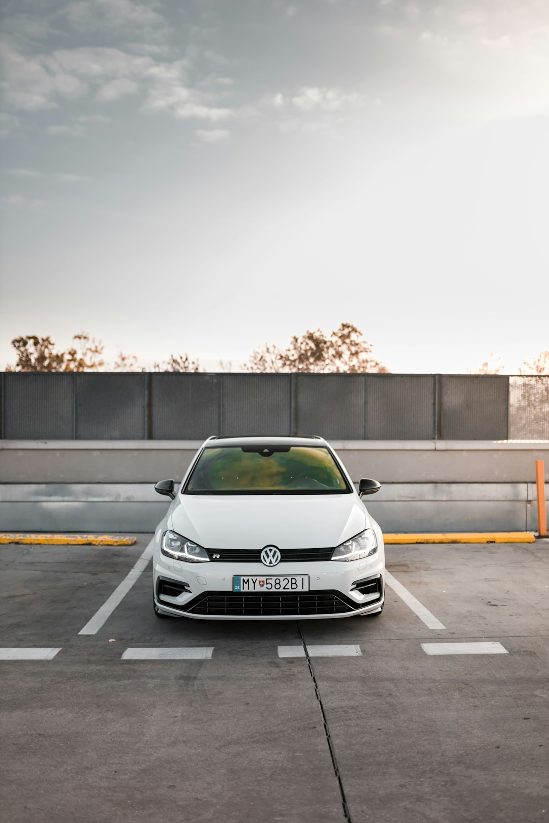 white Volkswagen car parked during white and blue cloudy sky