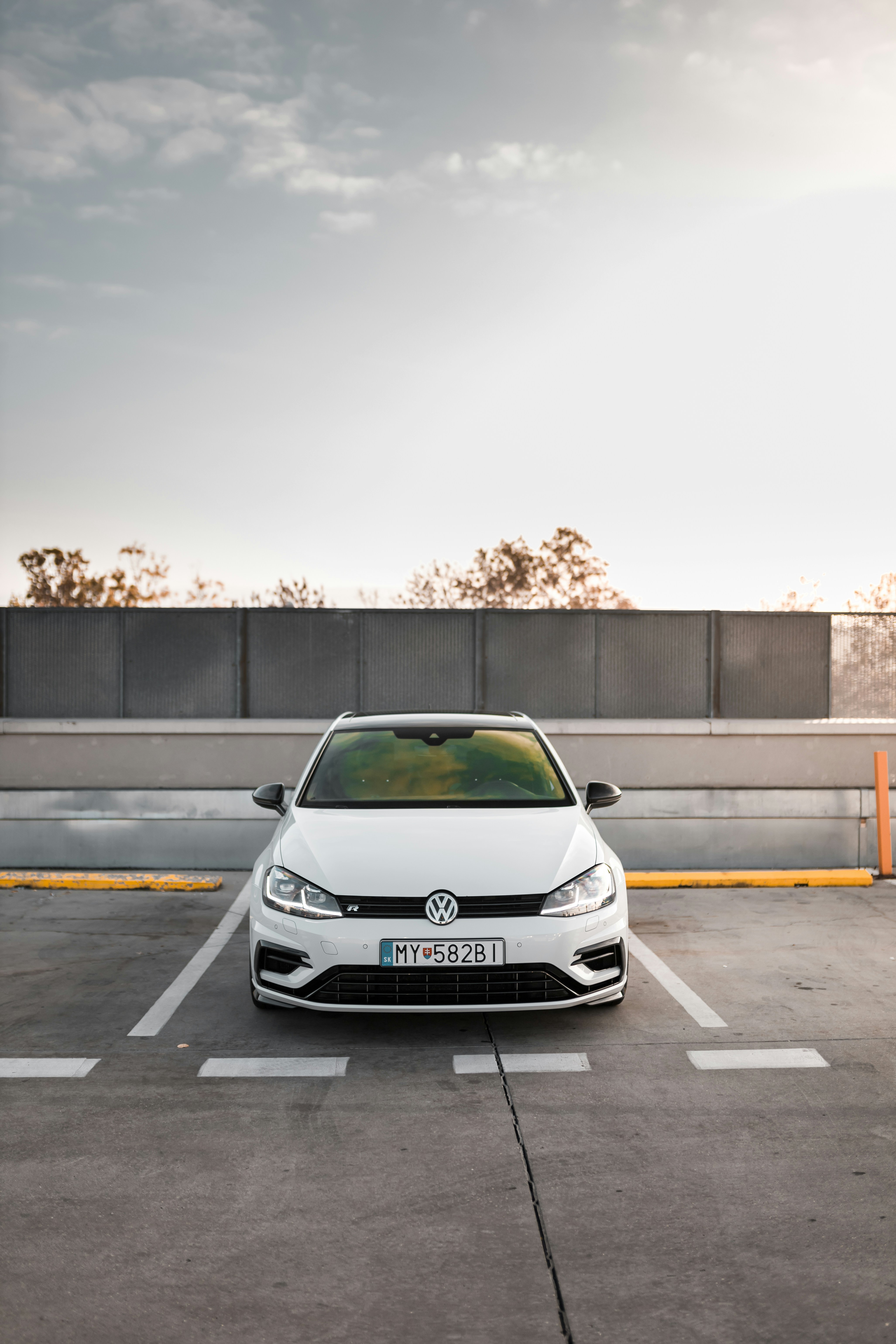 white Volkswagen car parked during white and blue cloudy sky