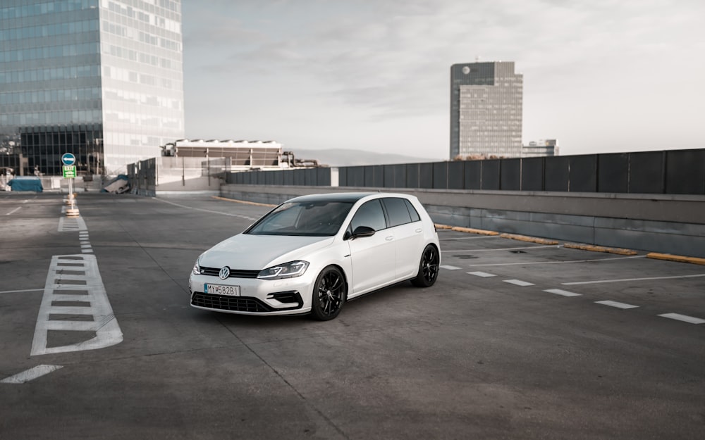 Volkswagen branco hatchback de 5 portas no estacionamento