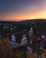 A serene European village with cobblestone streets and historic stone houses under a soft sunset
