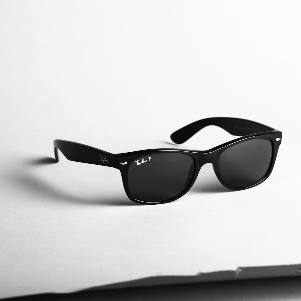 foto con messa a fuoco superficiale di occhiali da sole Ray-Ban wayfarer neri