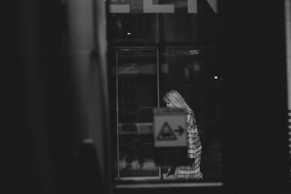 gray-scale photography of woman wearing black and white dress covered by caution sticker