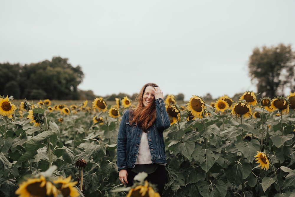 woman standing in the middle of sunflower field