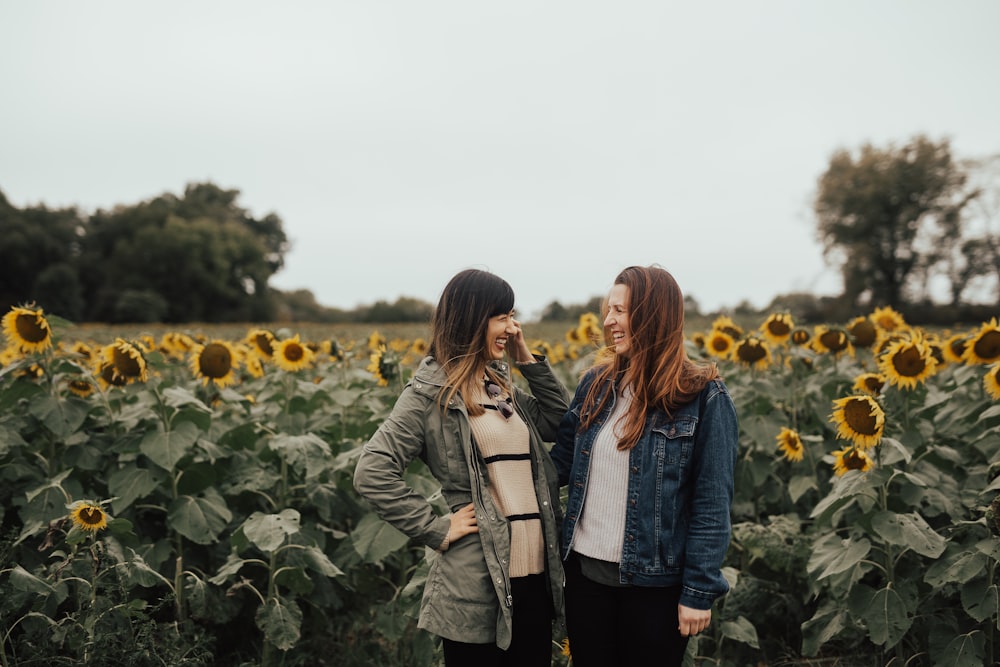 two women near yellow sunflowers