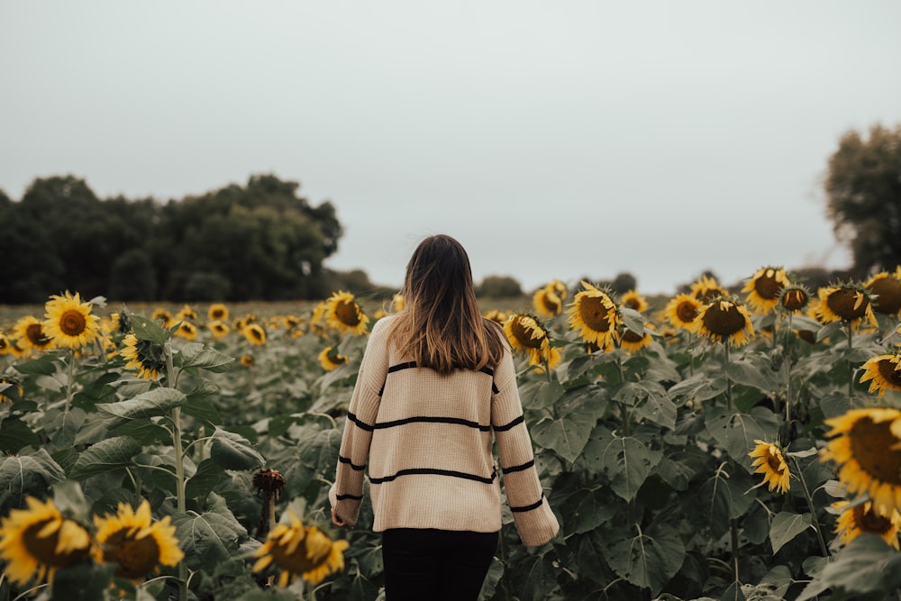 woman standing field of sunflower