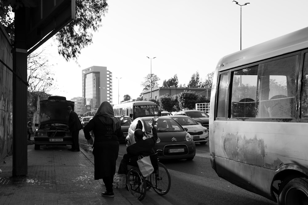 grayscale photo of man riding wheelchair