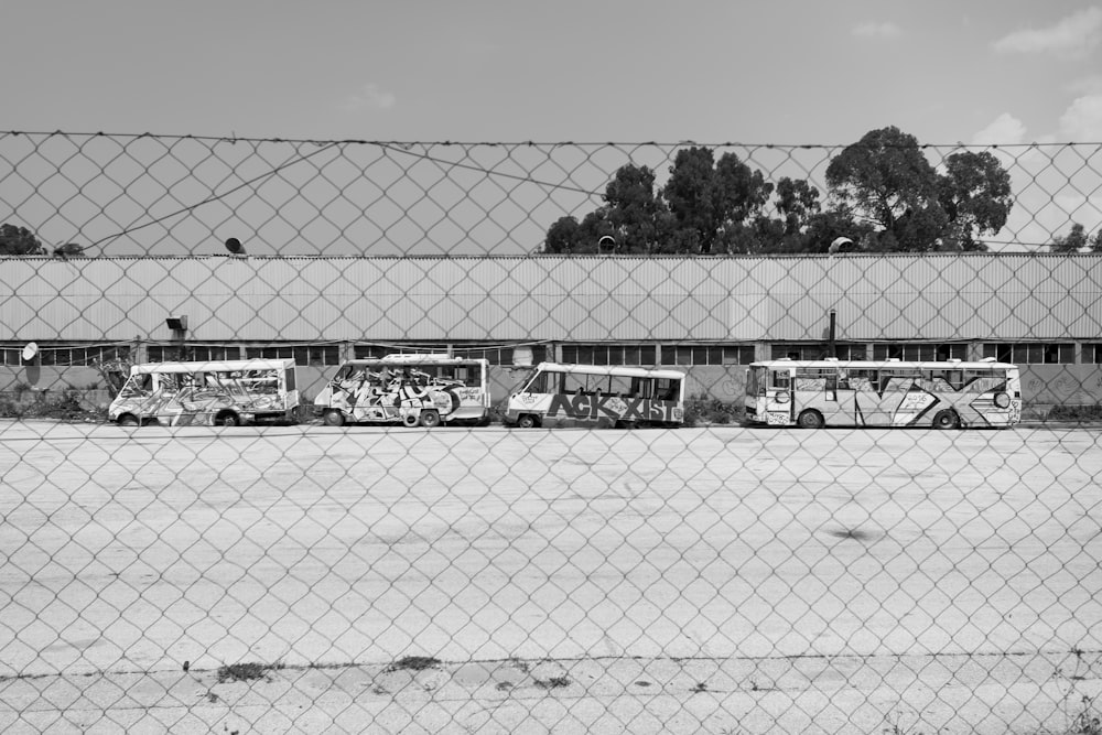 grayscale photo of four buses