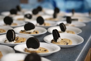 An overhead shot of a variety of kreo cookies arranged artfully on a black slate board
