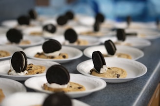 An overhead shot of a variety of kreo cookies arranged artfully on a black slate board