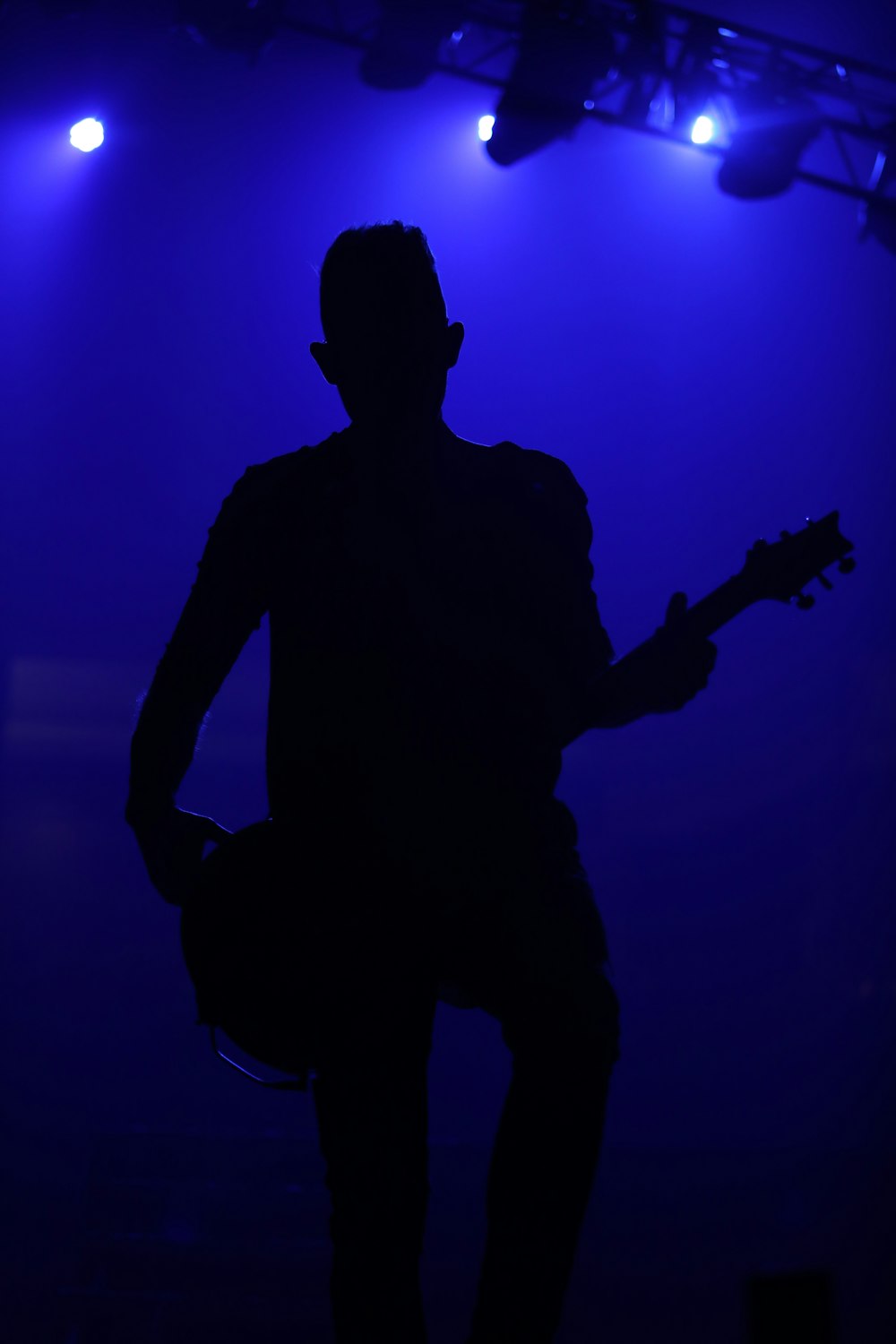 a silhouette of a man playing a guitar