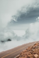 A winding mountain path disappearing into clouds, inviting exploration.