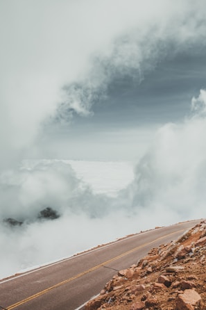 A winding mountain path disappearing into clouds, inviting exploration.