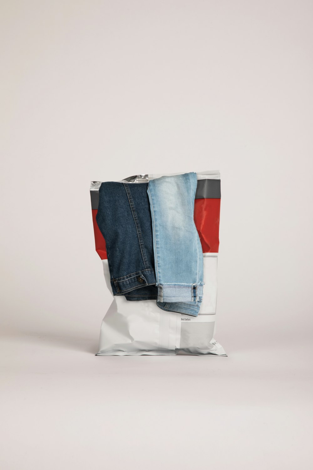 two blue and gray denim jeans on white plastic bag