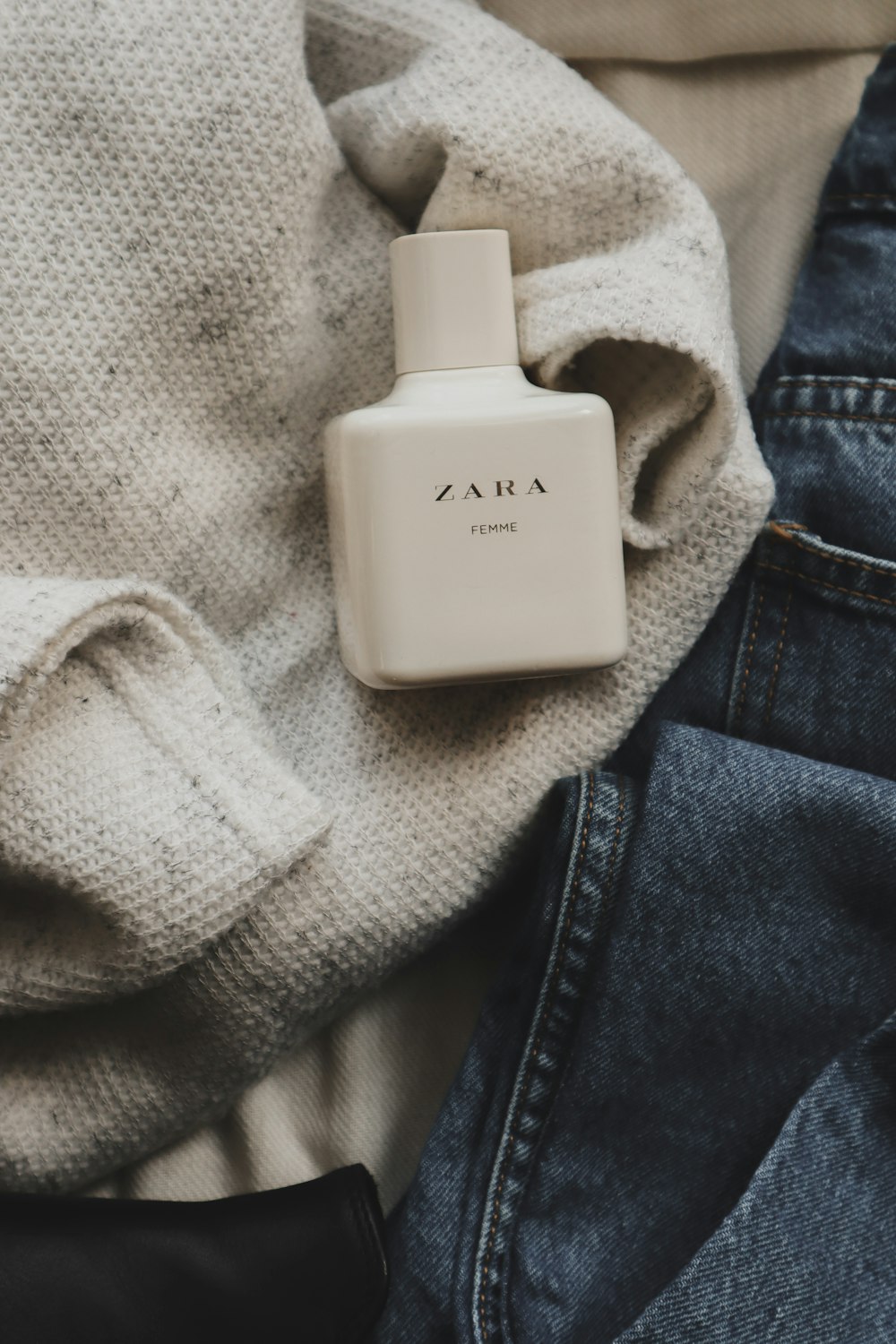 white Zara plastic perfume bottle on white textile