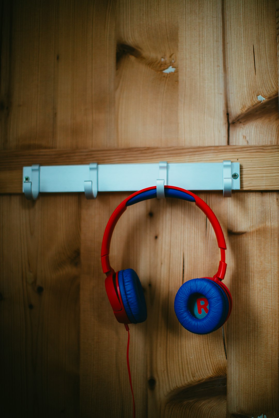 red and blue headphones on hook