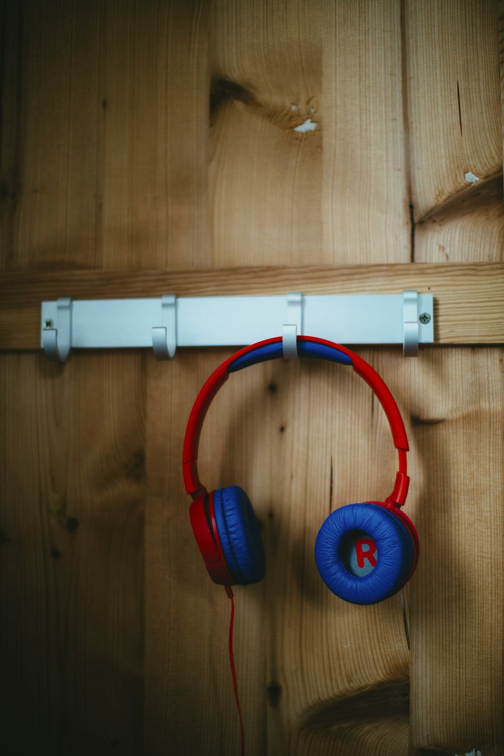 red and blue headphones on hook