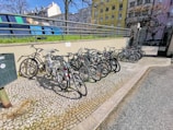 A row of refurbished bicycles lined up outdoors on a sunny day.