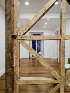 A sturdy wooden frame taking shape inside a home, illuminated with subtle blue accents against a dark backdrop.