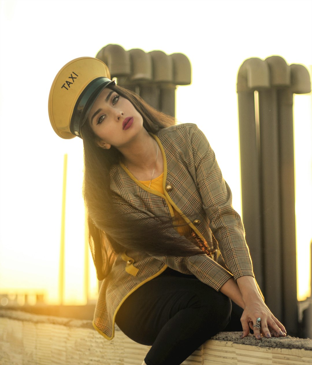 woman sitting on gray concrete wall