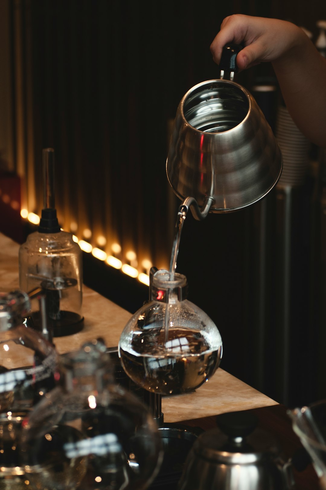 gray stainless steel teapot pouring water on glass bottle