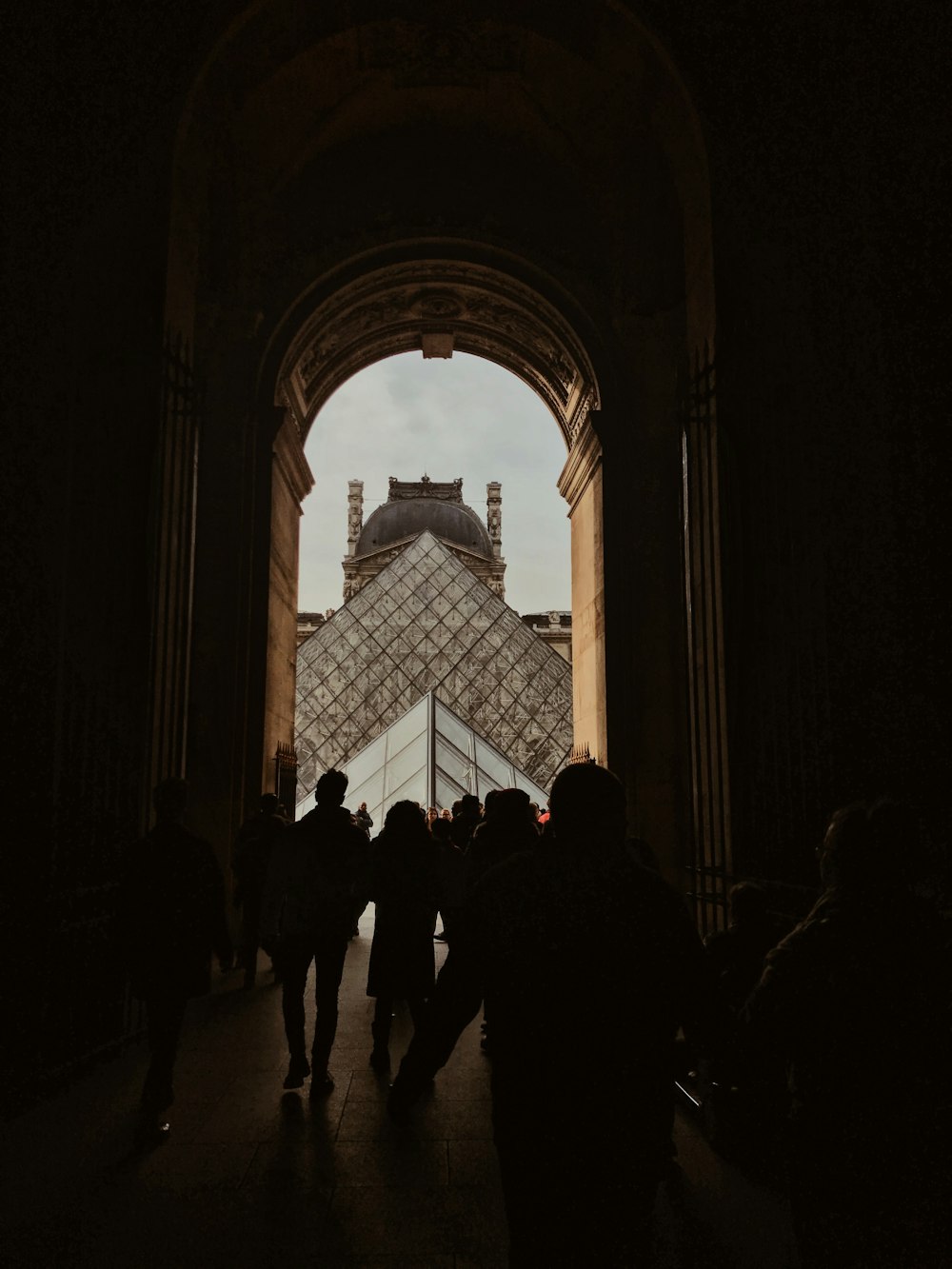 a group of people walking under an arch in a building