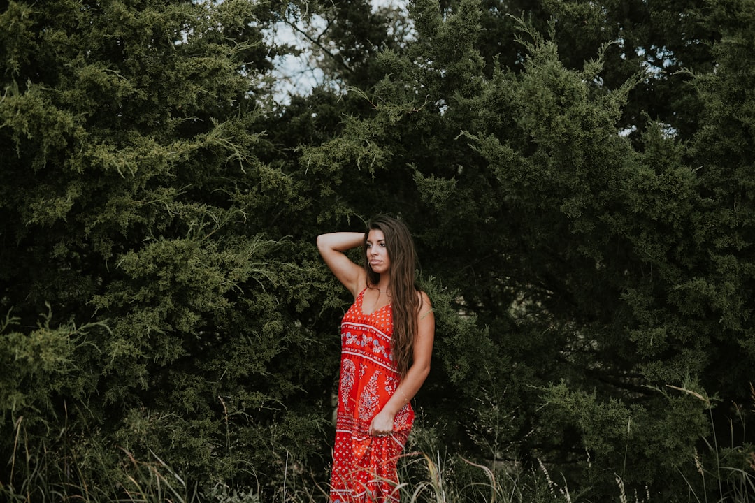 standing woman wearing red sleeveless dress during daytime