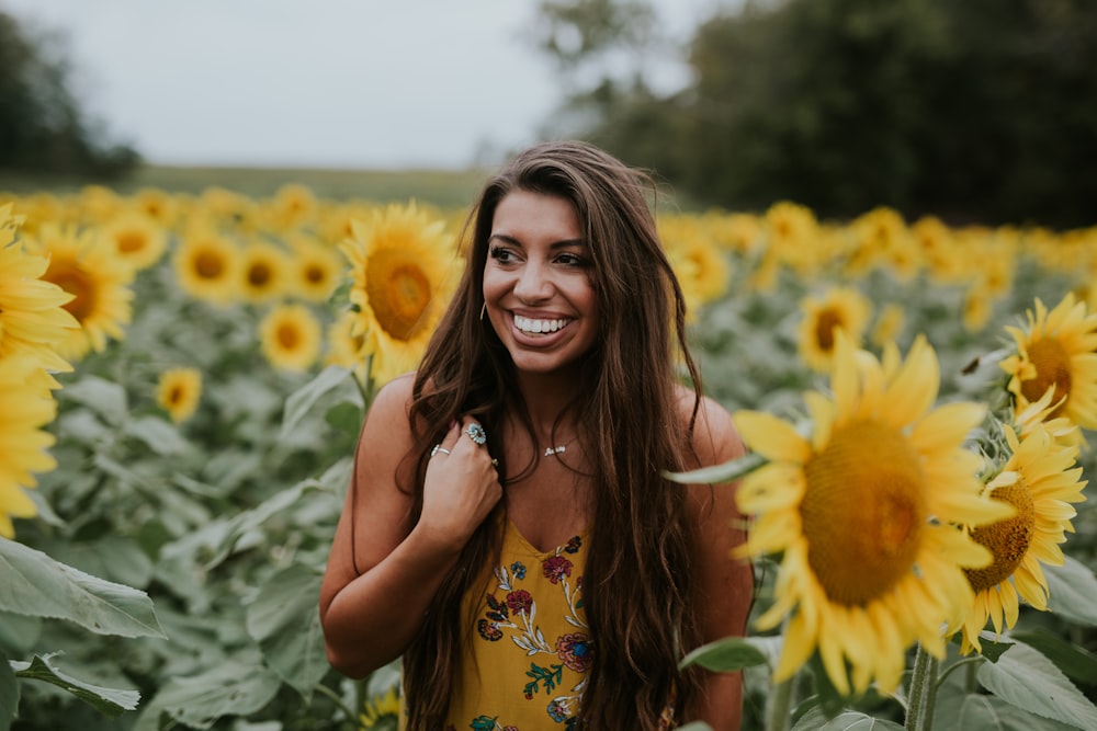 woman standing beside sunflowers