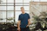 man in blue crew-neck top standing near plants