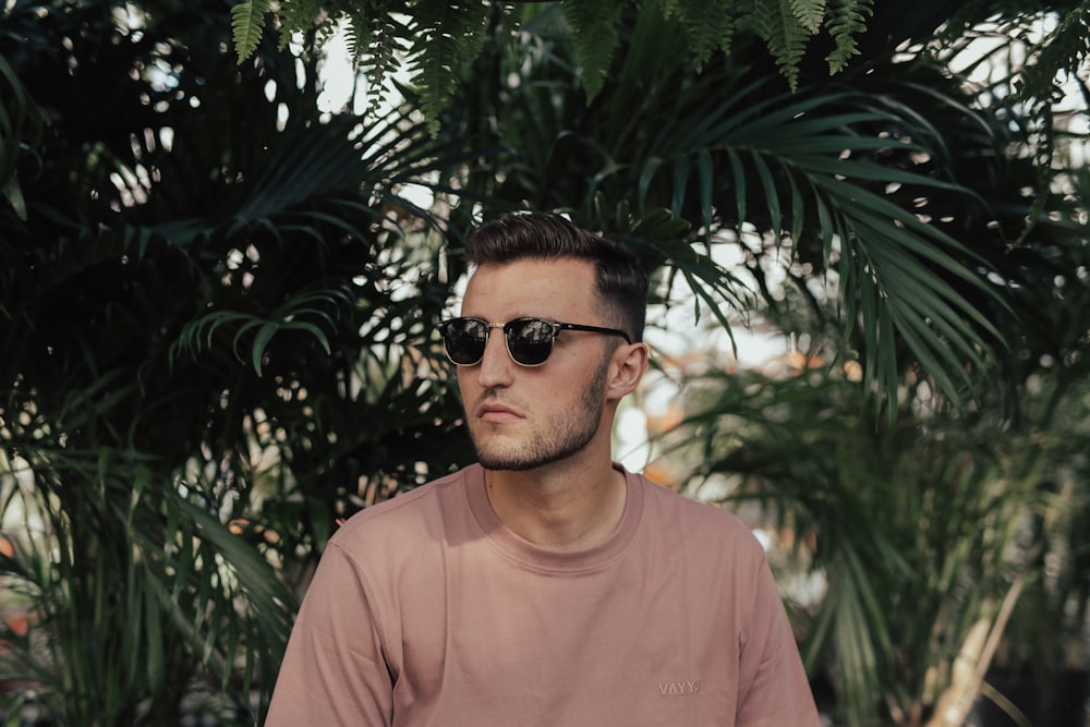 man standing near green leaf plant