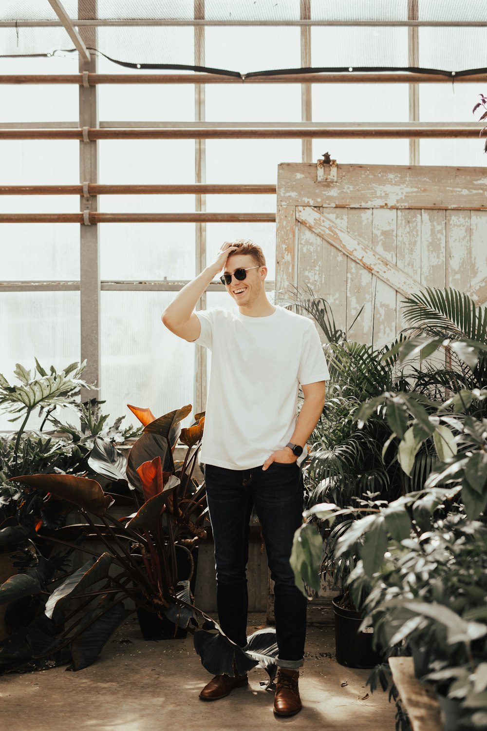 man standing surrounded by potted flowers