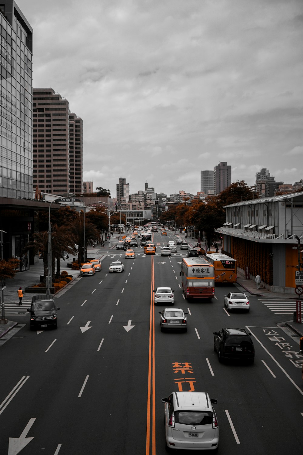 cars passing by gray buildings