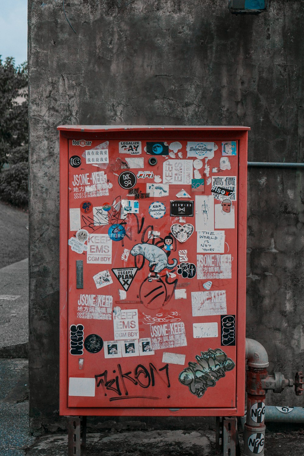 red metal board beside gray wall