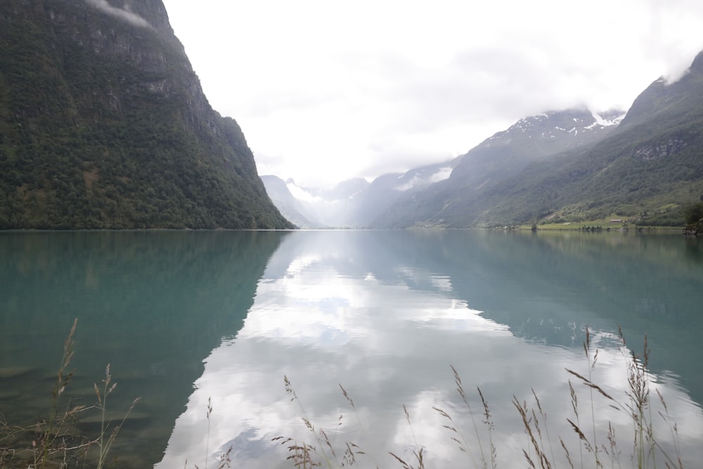 mountains near body of water under cloudy sky