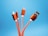 Four charging cables with orange braided coverings and various connectors, including USB and micro-USB, against a vibrant blue background.