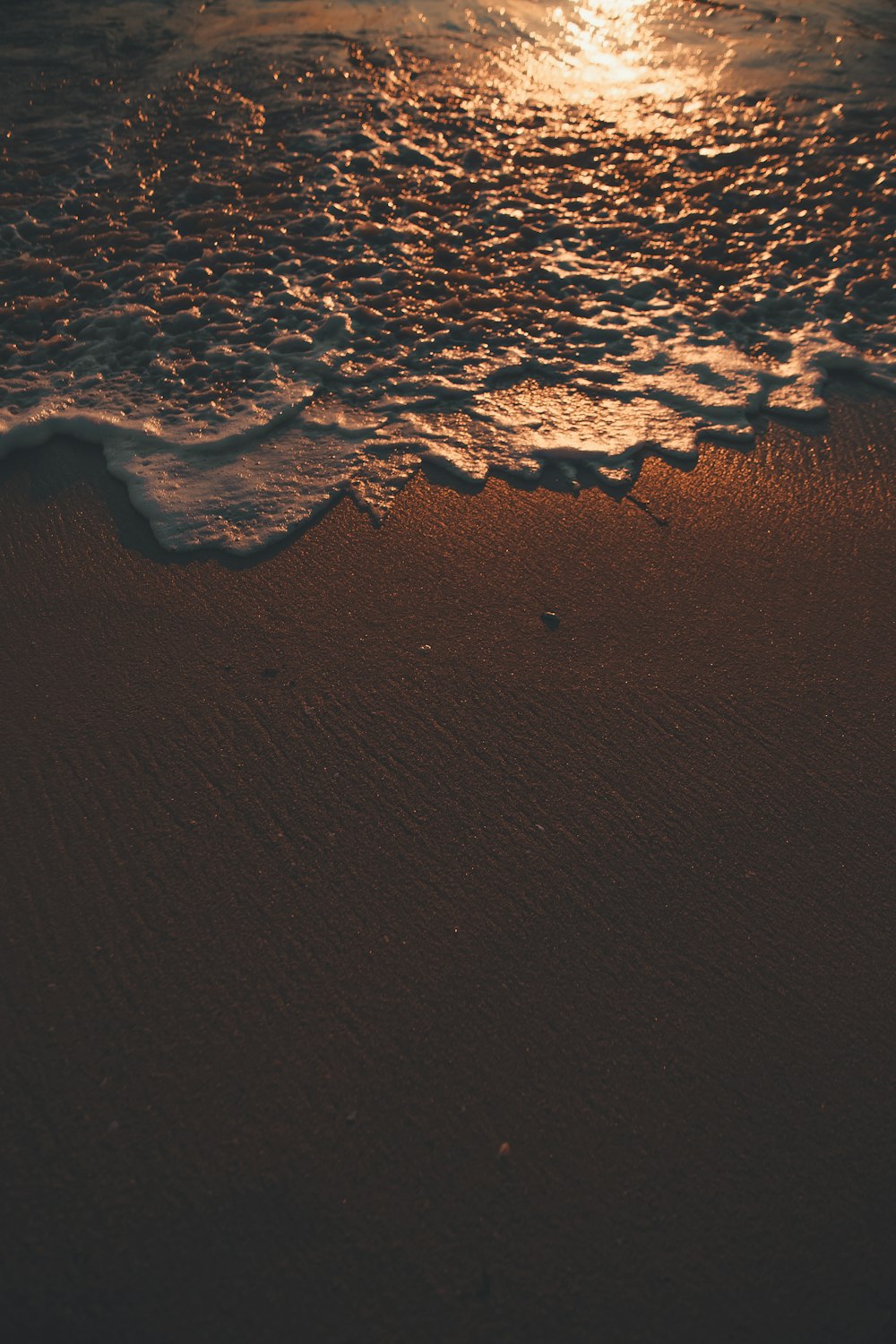 waves rush to shore during sunset