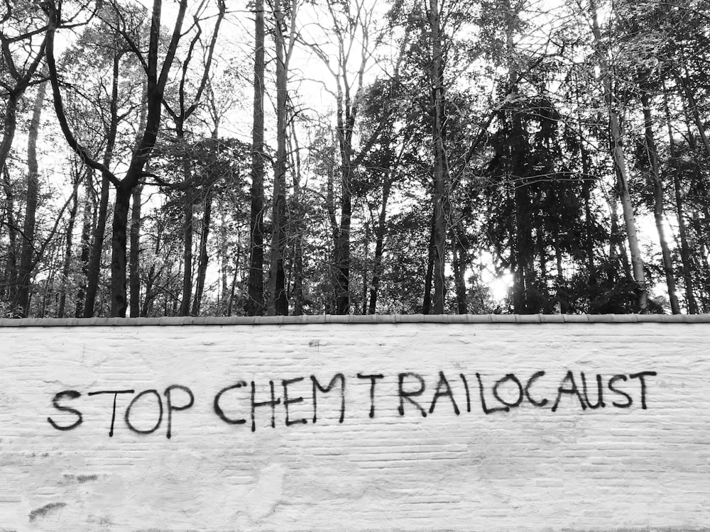 a black and white photo of a sign that says stop chemtrailogast