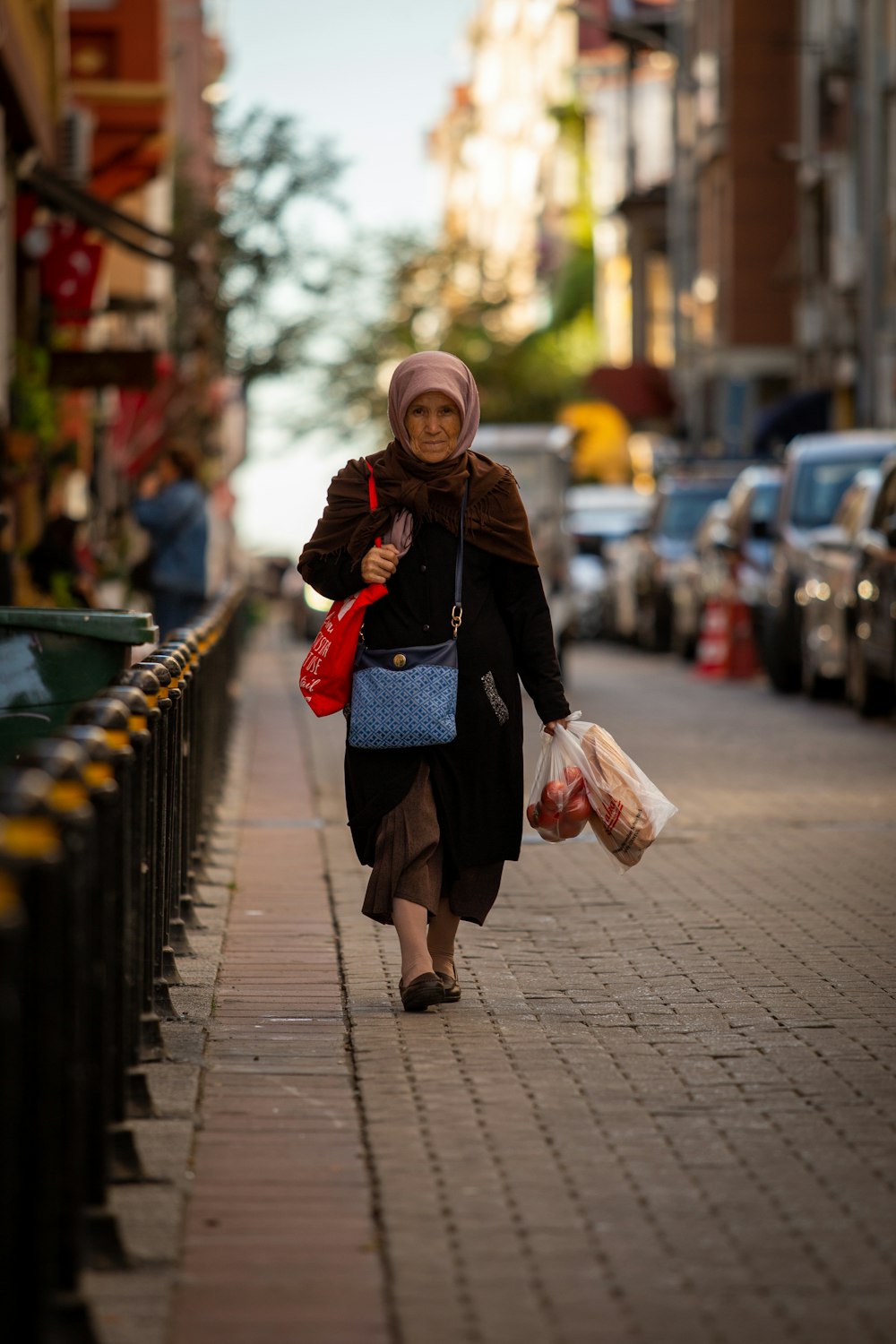 woman walking beside metal barricades