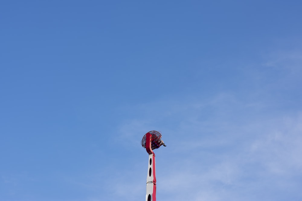 a red and white pole with a light on top