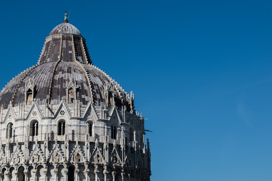 grey concrete dome under blue calm sky in Piazza dei Miracoli Italy