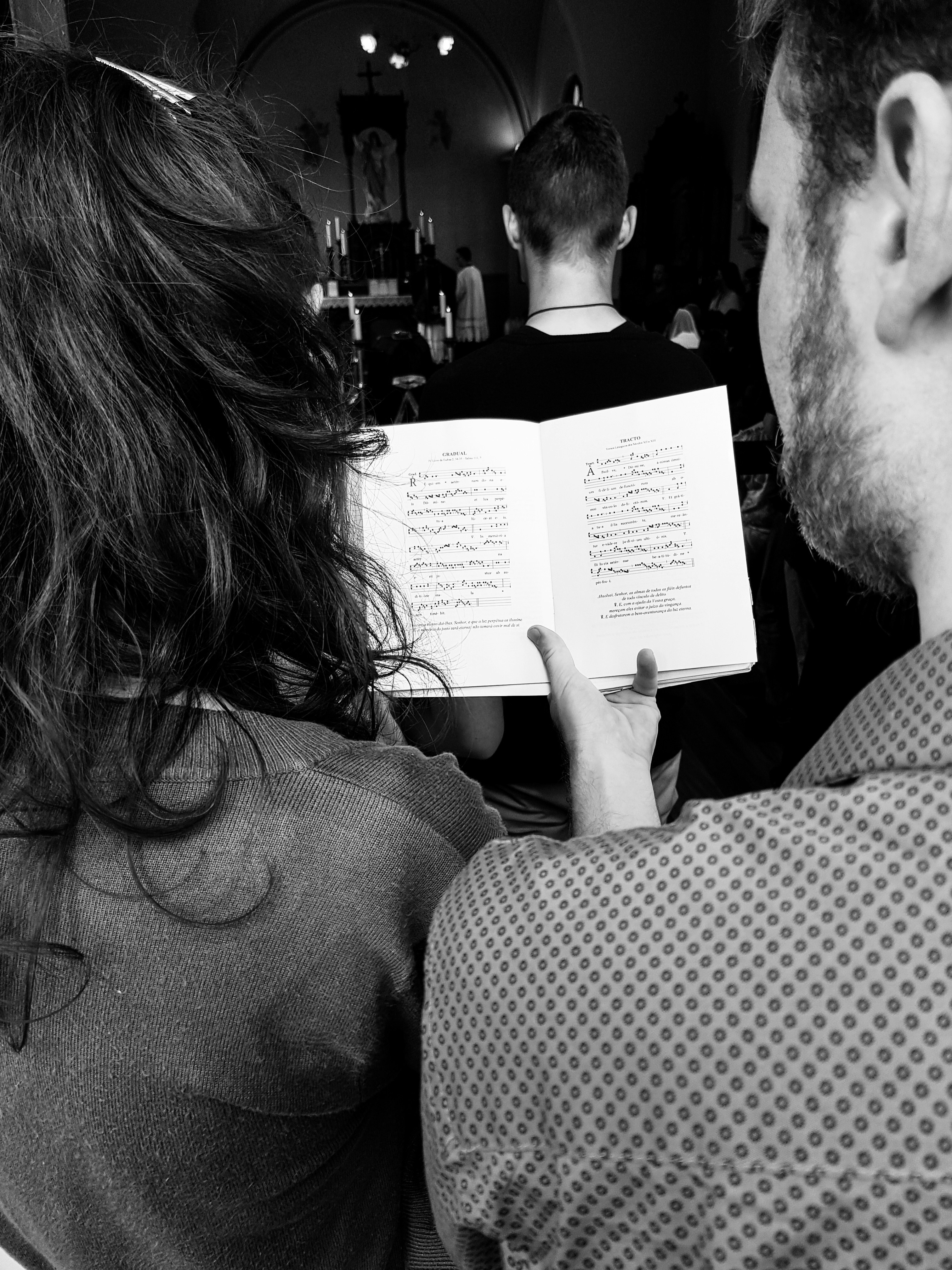 grayscale photo of man holding book